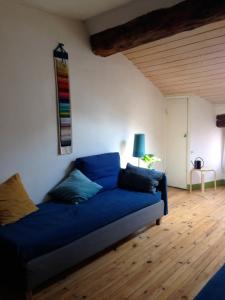 a living room with a blue couch in a room at Le Velo Rouge in Le Puy en Velay