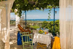 a table and chairs with a view of the ocean at Mayra Apartment in Lithakia
