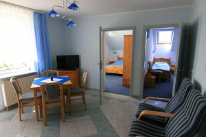 ein Wohnzimmer mit einem Tisch und ein Schlafzimmer in der Unterkunft Mikolaj in Białogóra