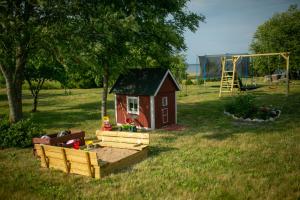 uma pequena casa num campo com um parque infantil em Rannamäe Apartments em Suur-Rootsi