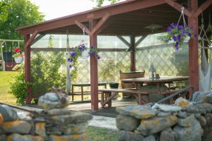 a wooden pergola with a picnic table in a yard at Rannamäe Apartments in Suure-Rootsi