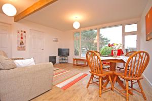a living room with a table and chairs and a couch at Mount Hawke Holiday Bungalows in Porthtowan