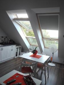 タルノフスキェ・グルィにあるSky view Condo in Tarnowskie Góryのキッチン(白いテーブル付)、窓2つが備わります。