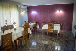 a dining room with tables and chairs and purple walls at Pensiunea Christiana in Arad