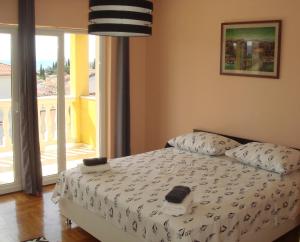 ein Schlafzimmer mit einem Bett und einem großen Fenster in der Unterkunft Apartments Jelicic in Selce