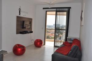 ein Wohnzimmer mit einem Sofa und einer Glasschiebetür in der Unterkunft Apartamentos em Olímpia próximos Thermas dos laranjais in Olímpia