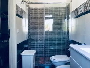 a bathroom with a toilet and a glass shower at Casa Alice in Syracuse