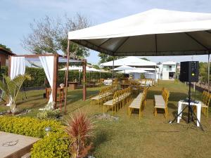 a group of tables and chairs under a white umbrella at Casa no Lago de Furnas in Pontevila