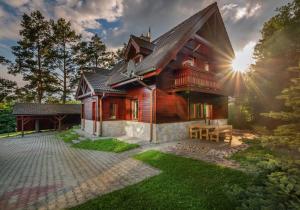 ein Holzhaus, hinter dem die Sonne scheint in der Unterkunft Oddy in Stará Lesná
