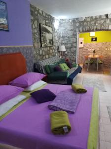 un soggiorno con un grande letto con lenzuola viola di Apartments Hana a Makarska