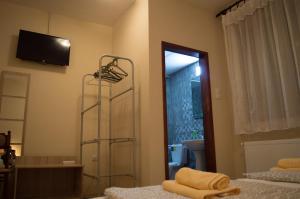 a bedroom with two beds and a television on the wall at Guest House Dimitrije in Niška Banja