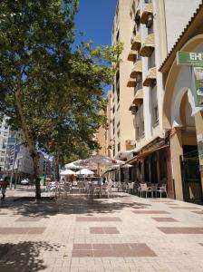 uma rua vazia com mesas e guarda-sóis numa cidade em Apartamento Domingo Lozano em Málaga