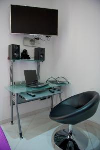 escritorio de cristal con ordenador portátil y silla en Maiorani Home en Nápoles