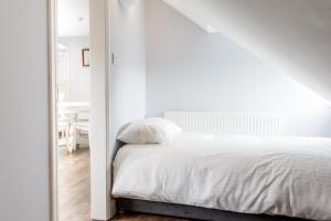 a bedroom with a white bed and a mirror at Molloys Apartments in Dublin