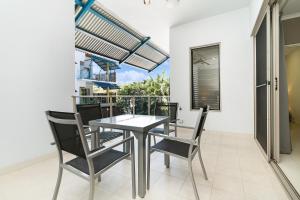 a dining room with a glass table and chairs at Elsey on Parap in Darwin