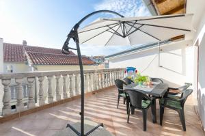 a patio with a table and an umbrella on a balcony at Apartment Marija in Vodice