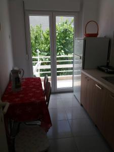 a kitchen with a table and a kitchen with a window at Mario's Apartment in Neos Marmaras +5 photos