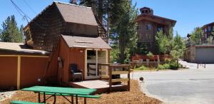 een tiny house met een picknicktafel voor een gebouw bij Tree House- Walk to Mammoth Village in Mammoth Lakes