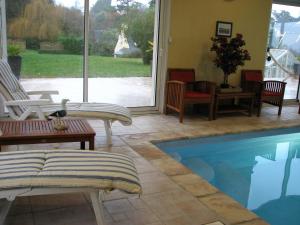 a patio with a pool and chairs and a table at L'Escale Evel Er Gêr in Locquirec