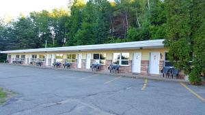 a building with tables and chairs in a parking lot at Stucco Lodge in Bangor