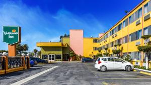 un coche aparcado en un aparcamiento frente a un hotel en Vagabond Inn Long Beach, en Long Beach