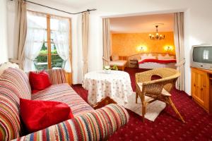 a living room with a couch and a bedroom at Landhotel Huberhof in Schwangau