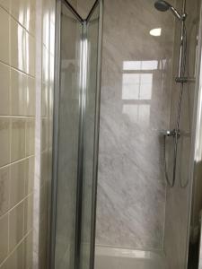 a shower with a glass door in a bathroom at Lion and Fiddle in Trowbridge