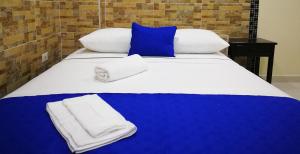 uma cama grande com lençóis e toalhas azuis e brancas em Hotel Zafiro em Letícia