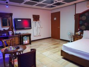 Plus Motel في بوسان: غرفة نوم بسرير وتلفزيون وطاولة