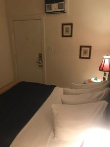 a bedroom with a bed with white pillows and a lamp at New Orleans House - Gay Male Adult Guesthouse in Key West