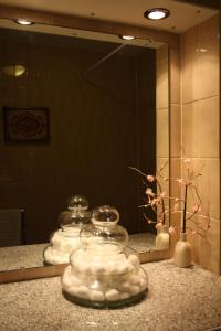 a bathroom counter with a mirror and several glass jars at 17 Wilmington Square in Eastbourne +60 photos