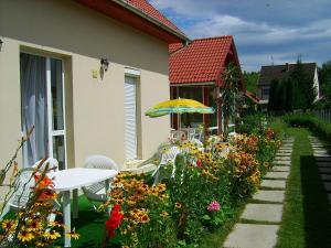 um pátio com uma mesa, guarda-chuva e flores em Agria Wellness Guesthouse em Eger