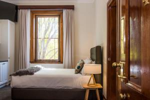 a bedroom with a bed and a window at The Parkview Hotel Mudgee in Mudgee