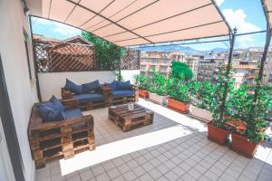 patio con sofá y mesas en el balcón en Il Viaggiatore Serapo, en Gaeta