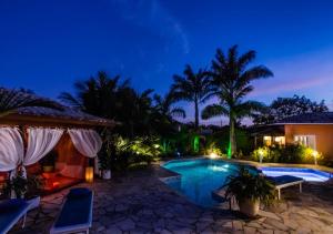 a villa with a swimming pool at night at Villa Baobá in Búzios