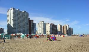 a group of people on a beach with buildings at Playa Club Argentina in Miramar