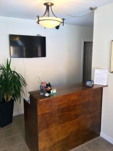a reception desk with a flat screen tv on the wall at Black Sea Motel in Penticton