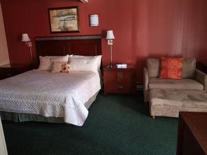 a hotel room with a bed and a chair at Townhouse Motel in Longview