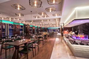a restaurant with tables and chairs and a bar at LiuZhou Imperial Dragon Bay Purejoy Hotel in Liuzhou