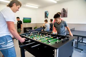 een man en een jongen die tafelvoetbal spelen bij NRMA Batemans Bay Resort in Batemans Bay