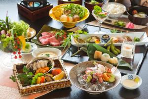 uma mesa com muitos pratos de comida em Kinsuikan em Miyajima