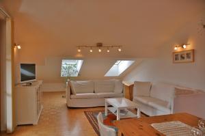 a living room with two white couches and a tv at Landhaus Mitsche in Hermagor