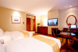 a hotel room with two beds and a television at Sejong Hotel Seoul Myeongdong in Seoul