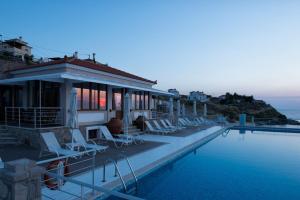 a house with a swimming pool next to the ocean at Little Bird Lesvos in Petra