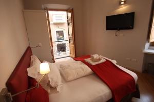 a bedroom with a bed with a red blanket on it at Numero 3 in Cagliari