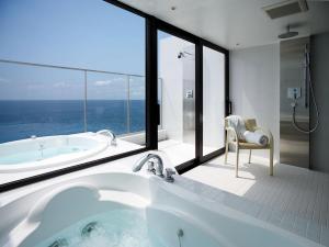 a bathroom with a tub and a large window at Scapes The Suite in Hayama