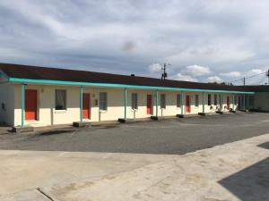 un gran edificio blanco con puertas rojas y azules en Budget Inn, en Donalsonville