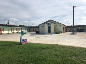 un edificio con un cartel de venta en un estacionamiento en Budget Inn, en Donalsonville