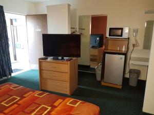 a hotel room with a flat screen tv and a bed at Townhouse Motel in Longview