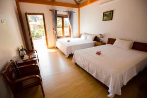 a bedroom with two beds with flowers on them at Tam Coc Cozy Homestay in Ninh Binh